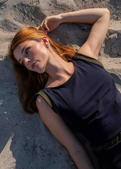 Model_laying_down_in_the_sand_wearing_Calanthe_jenny_top_in_navy_blue_cotton_with_color_block_details